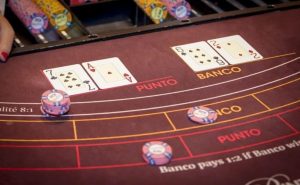 Dealer distribuindo cartas em jogo de baccarat ao vivo